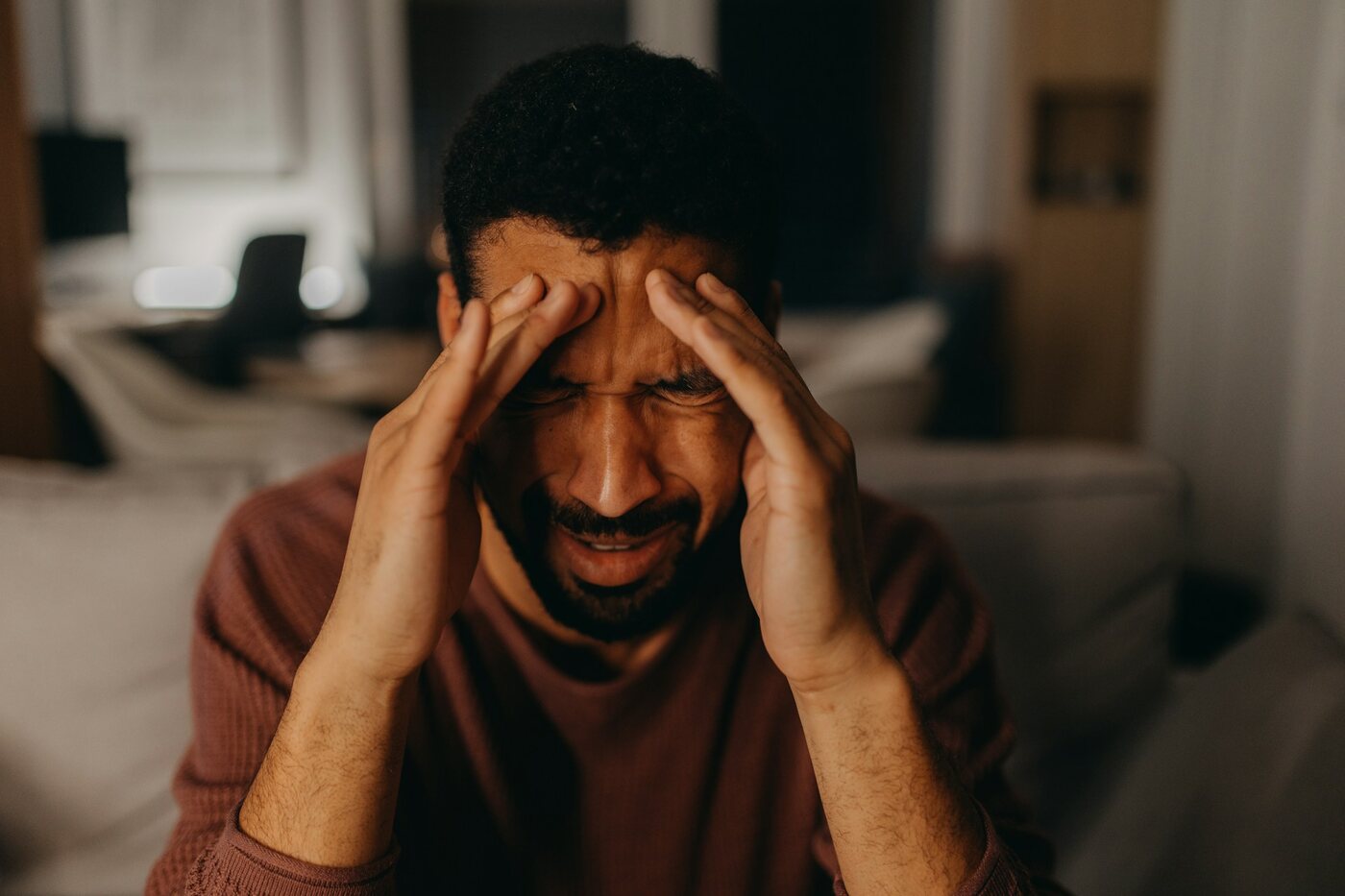 A person pressing their temples while experiencing a tension headache