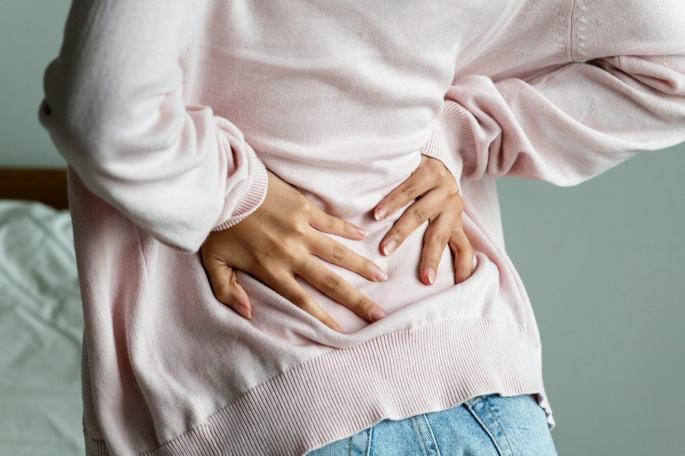 A person holding their lower back and hip where sciatica pain travels