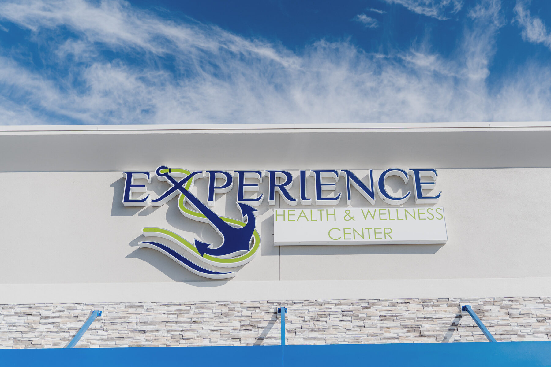 Experience Health & Wellness Center signage against a blue Florida sky